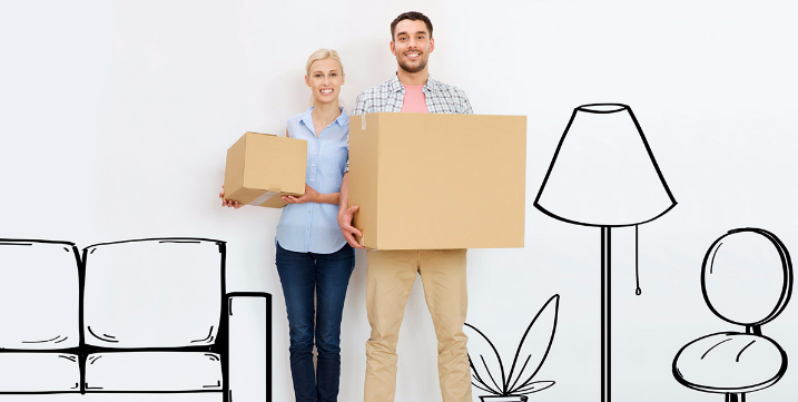 Young couple holding moving boxes for their new home